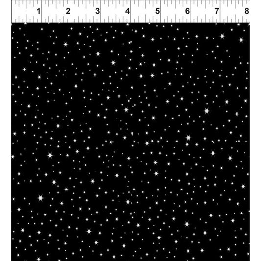 Black fabric with scattered white stars and a ruler at the top for scale.