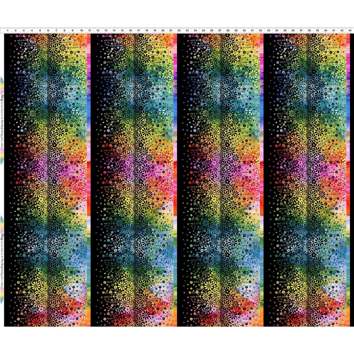 Fabric with four vertical stripes of colorful rainbow flowers, shown on a black background. Ruler along the top edge for scale.