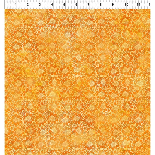 A fabric swatch featuring a repeating pattern of daisy-like flowers on a warm orange and yellow background, with a white ruler along the top edge for scale.