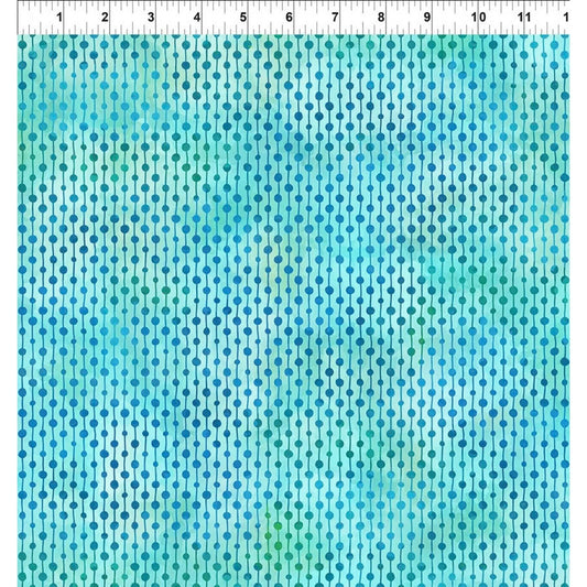 A fabric swatch with repeating dotted rows in aqua, turquoise, teal, and light blue tones, with a white ruler along the top edge for scale.