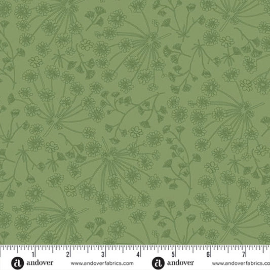 Green fabric with a repeating dark green botanical pattern of wildflowers and stems, shown with a white ruler along the bottom edge for scale.