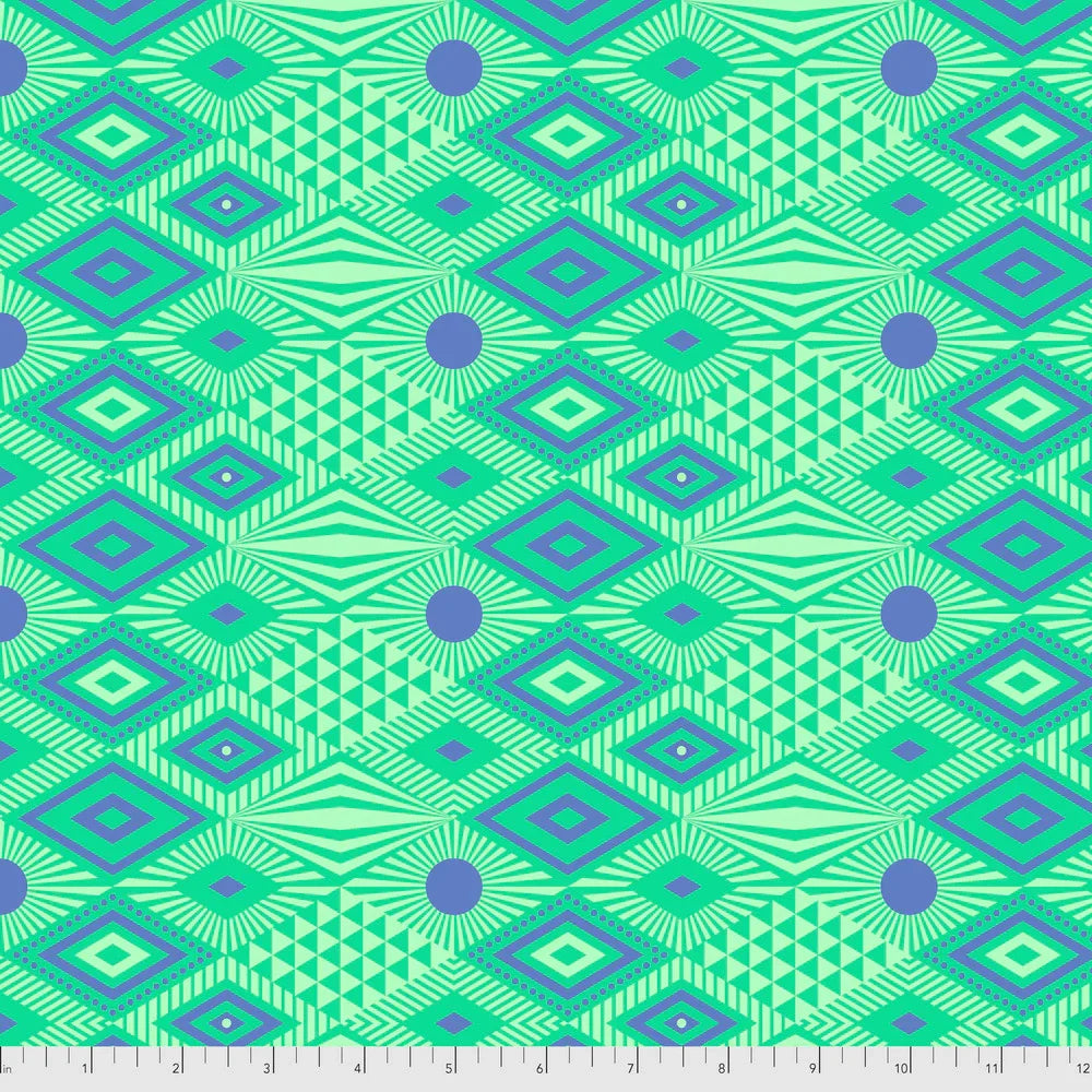 Geometric pattern with indigo blue shapes on a green background with a ruler for scale