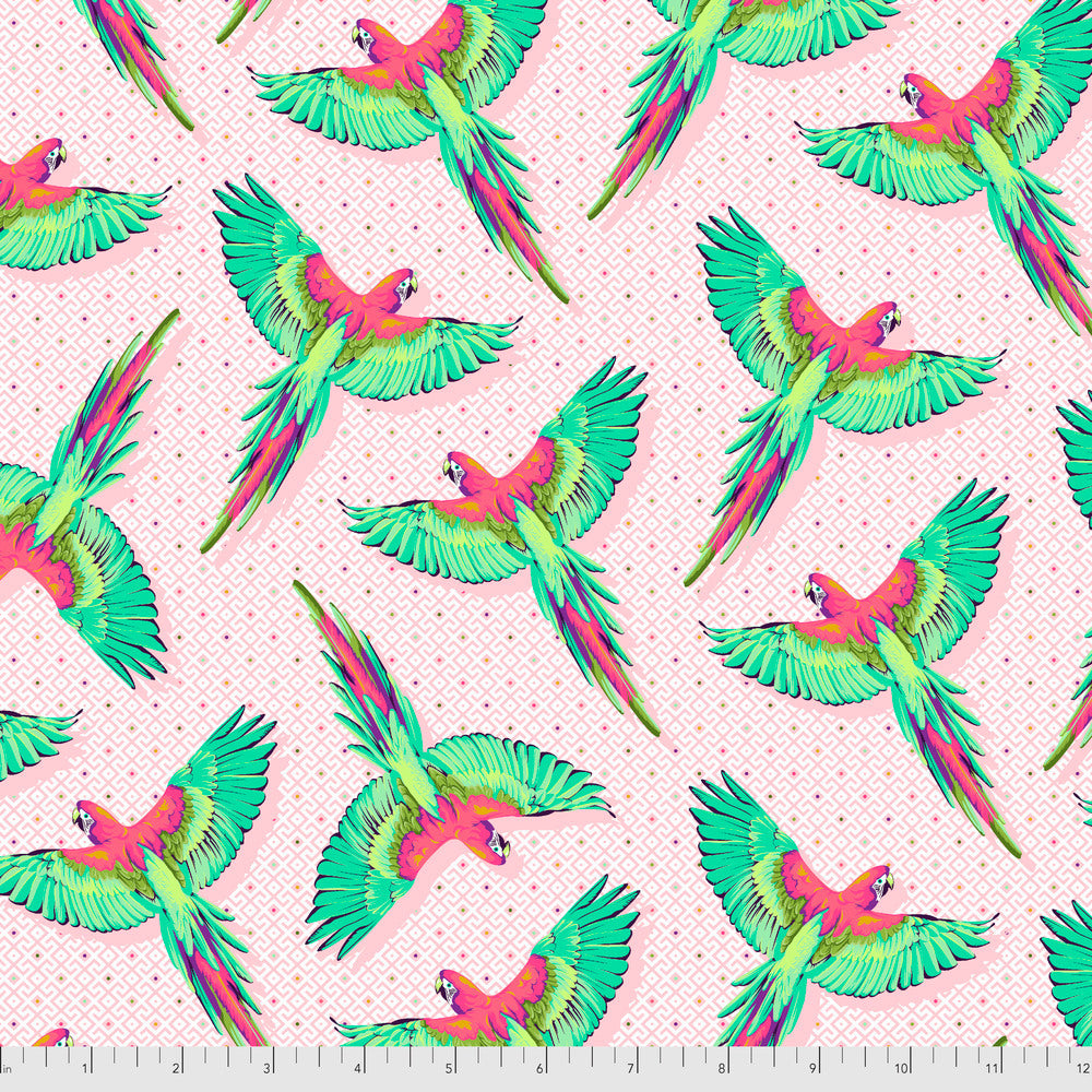 Pattern of colorful parrots on a light pink background with a ruler for scale