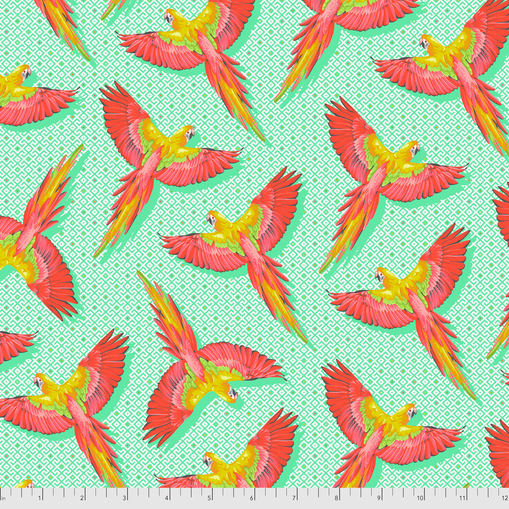 Pattern of colorful parrots on a turquoise green background with a ruler for scale