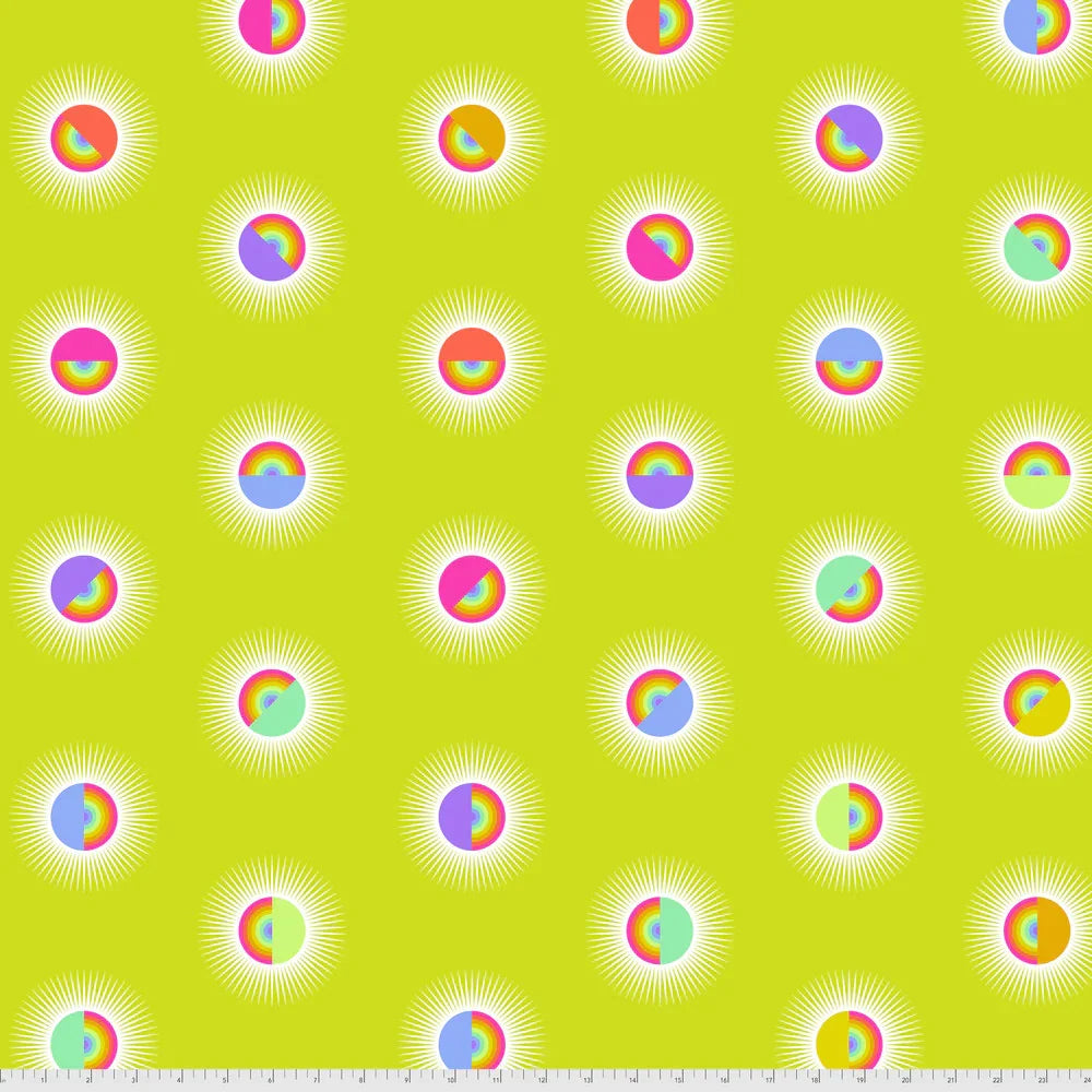 Pattern of colorful rainbow circles on a yellow background with a ruler for scale