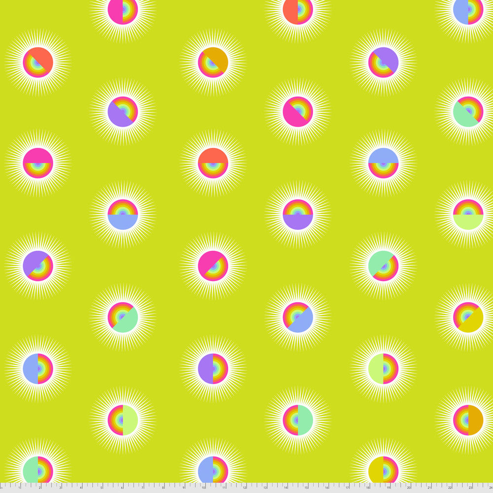 Pattern of colorful rainbow circles on a yellow background with a ruler for scale