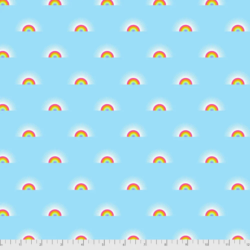 Pattern of small rainbows on a blue background with a ruler for scale.