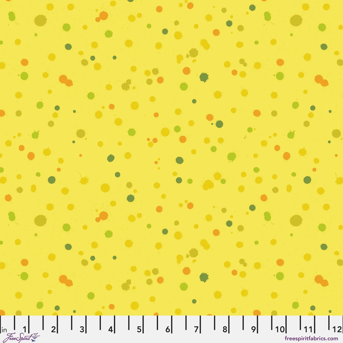 Fabric design of paint droplets in olive, orange, and chartreuse tones scattered across a warm, sunny yellow background. Ruler at the bottom for scale.