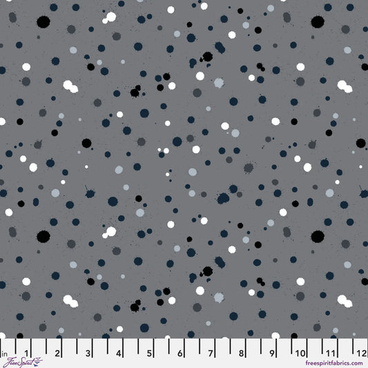 Fabric design with paint drops in black, white, and slate-grey tones scattered across a medium grey background. Ruler at the bottom for scale.