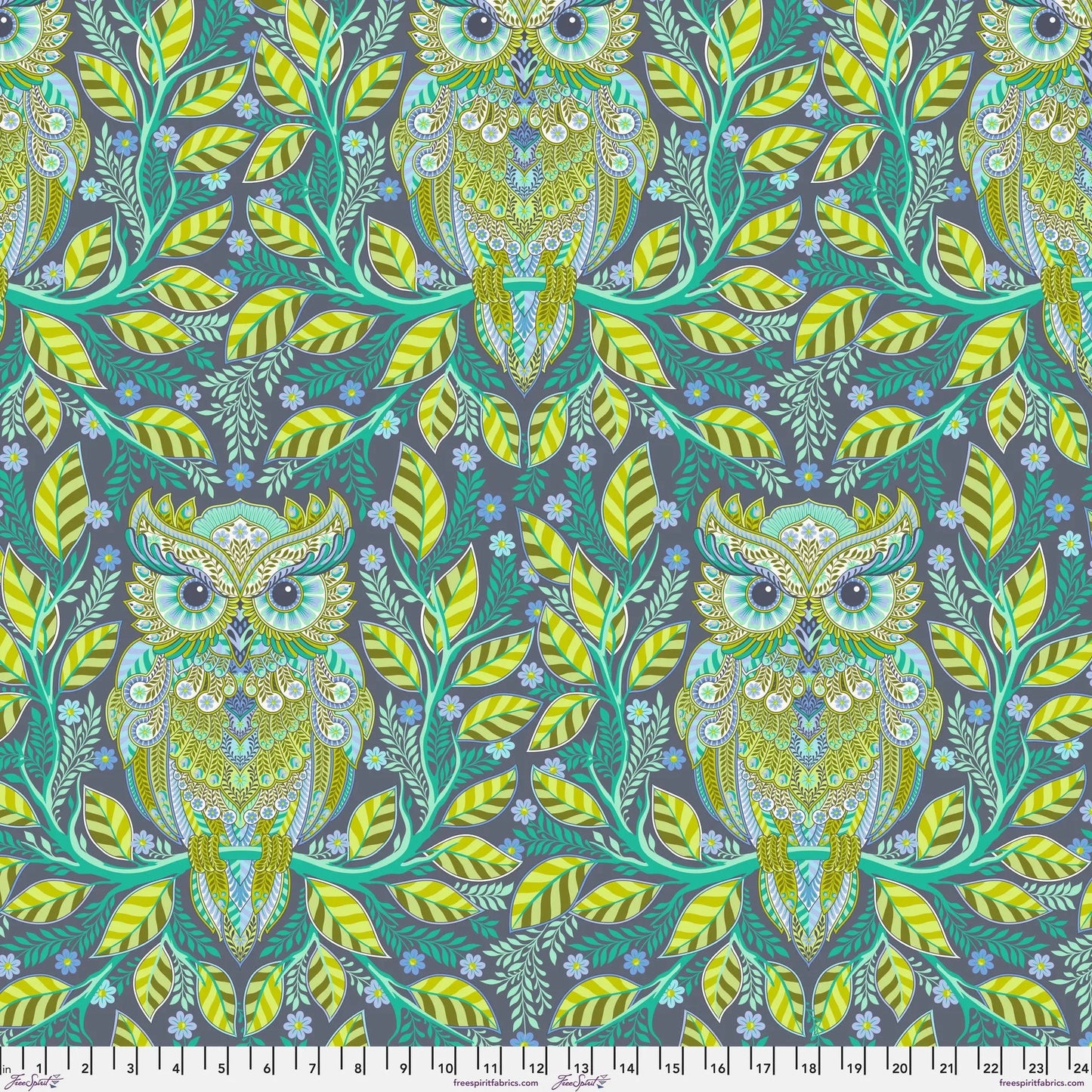 Pattern of green owls and leaves on a dark blue background with a ruler for scale