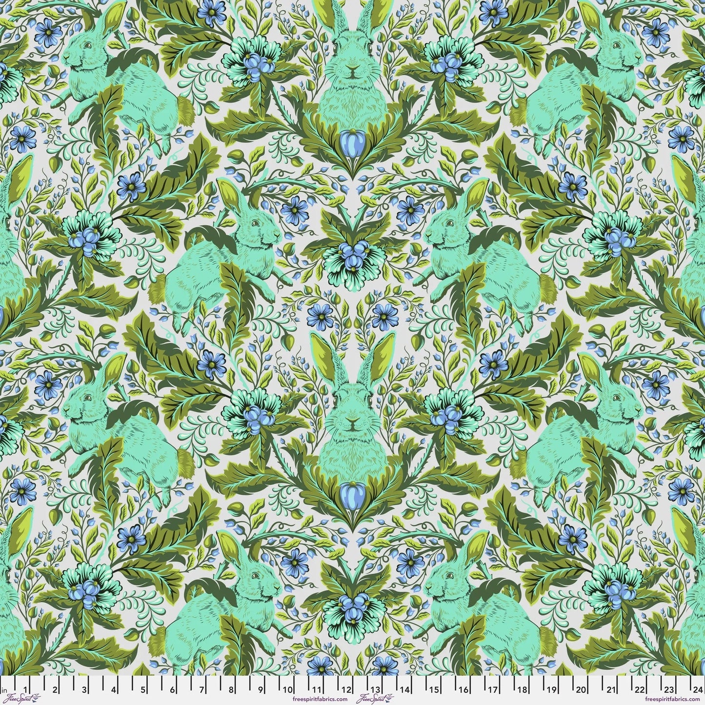Patterned fabric with green rabbits and blue flowers on a green background with a ruler for scale.
