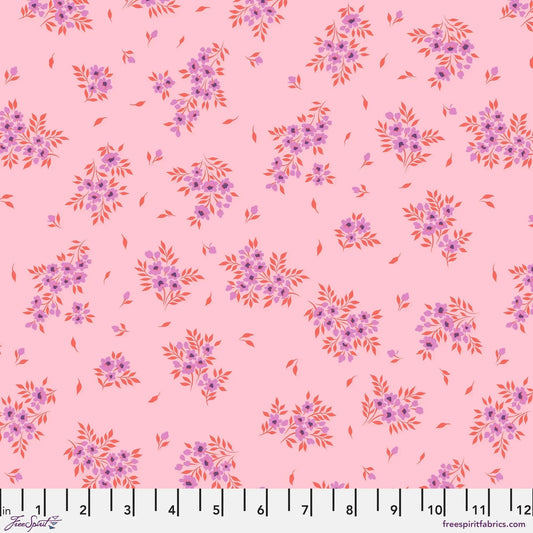 small sprays of purple flowers scattered across a light pink background with a ruler for scale