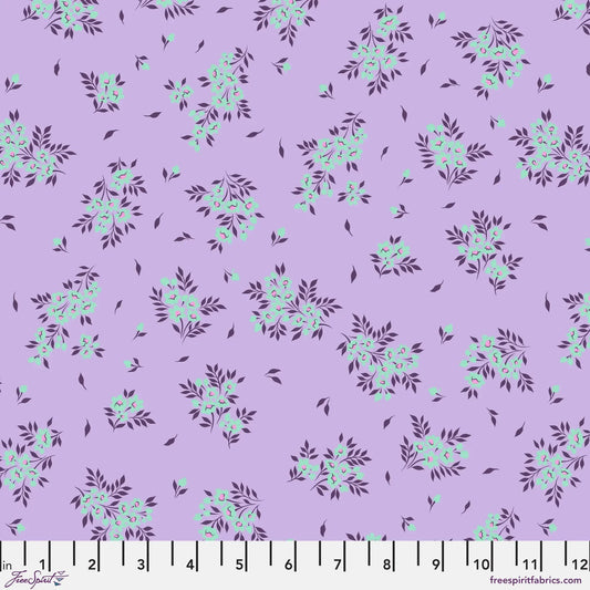 small sprays of aqua flowers scattered across a light purple background with a ruler for scale