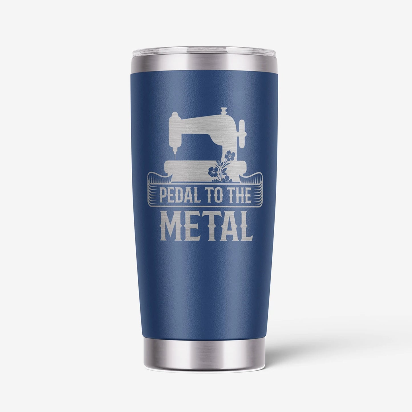 A navy blue insulated travel tumbler with a stainless steel lid and base, featuring a white graphic of a sewing machine and the text 'PEDAL TO THE METAL'.