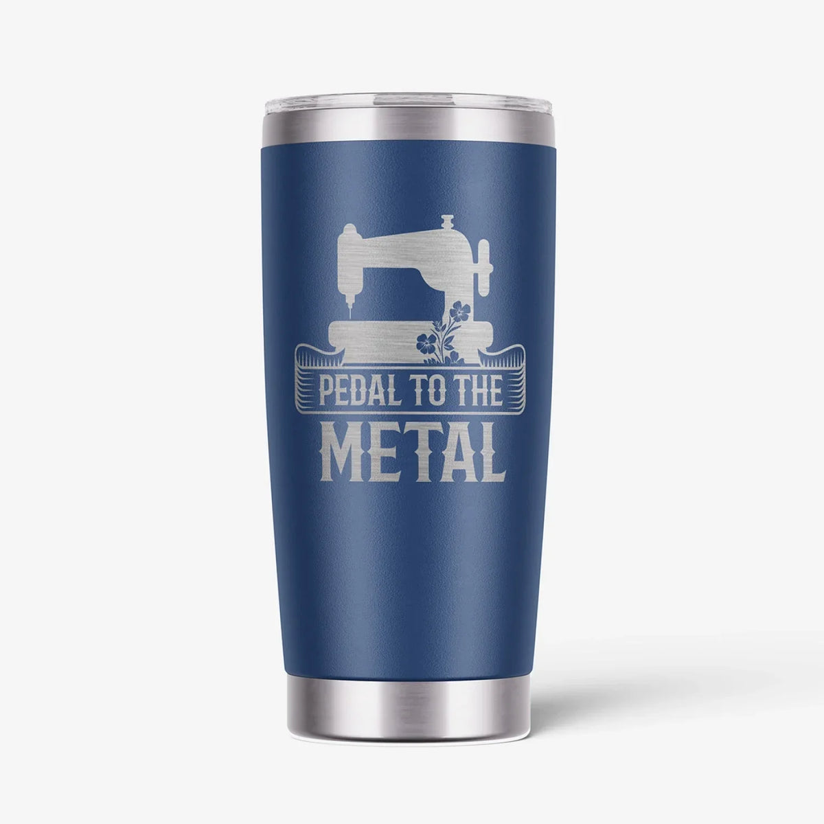 A navy blue insulated travel tumbler with a stainless steel lid and base, featuring a white graphic of a sewing machine and the text 'PEDAL TO THE METAL'.