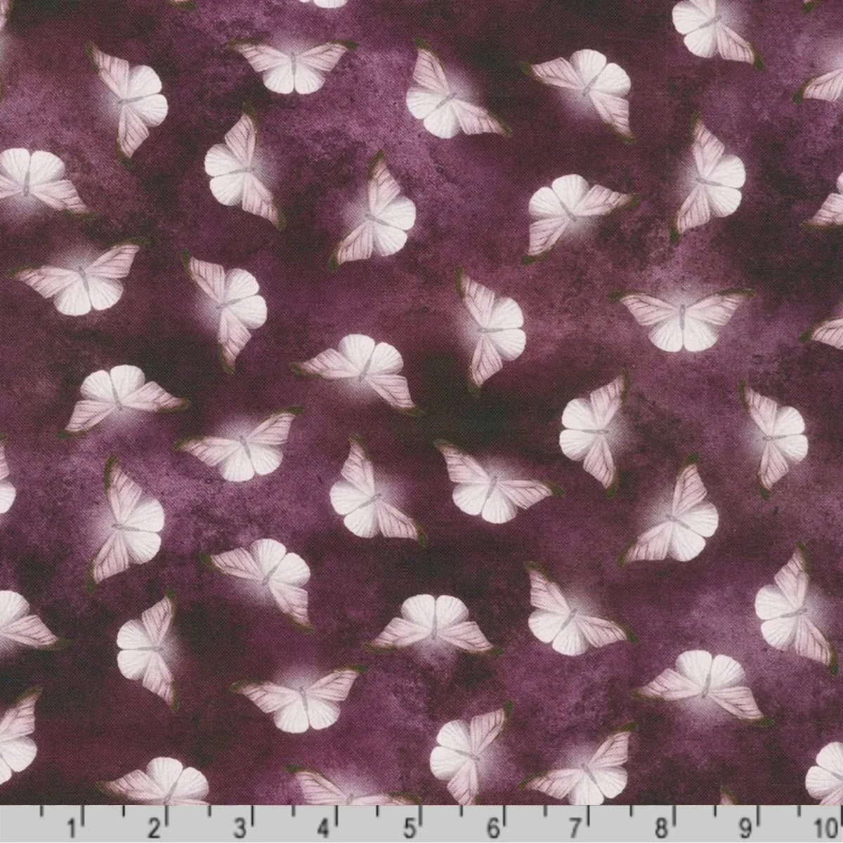 Patterned fabric of softly glowing white moth silhouettes scattered across a dark, mottled amethyst-purple background with a ruler at the bottom for scale.
