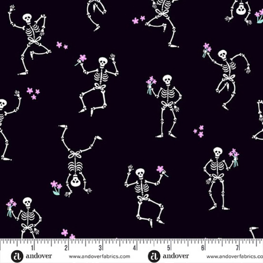 Pattern of dancing white skeletons with flowers on a black background with a ruler for scale.