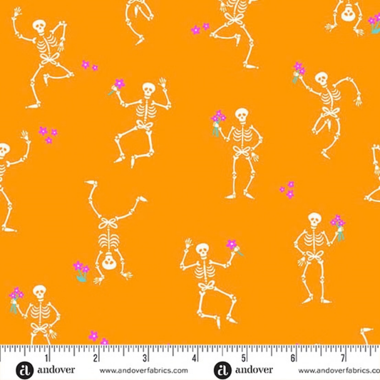 Pattern of dancing skeletons with pink flowers on an orange background with a ruler for scale.