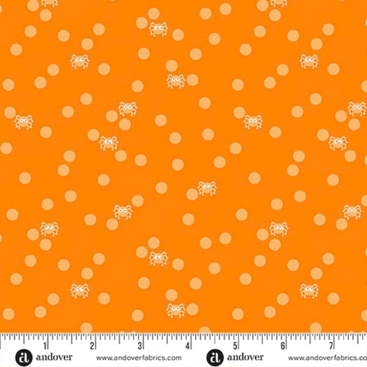 Orange fabric with peach polka dots and small cartoon spiders with a ruler for scale