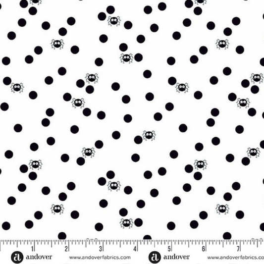 Pattern of black polka dots with small cartoon spiders on a white background with a ruler for scale
