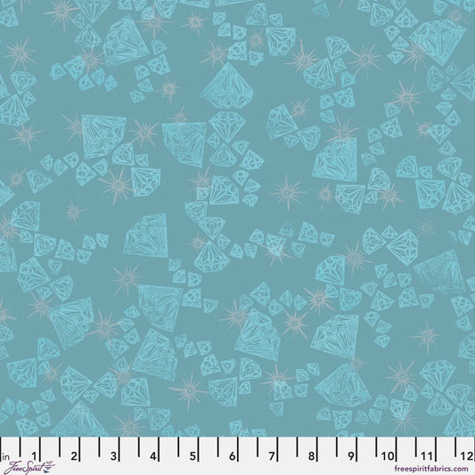 Pattern of aqua blue diamond shapes on a teal blue background accented with silver-grey sparkles. Ruler for scale.