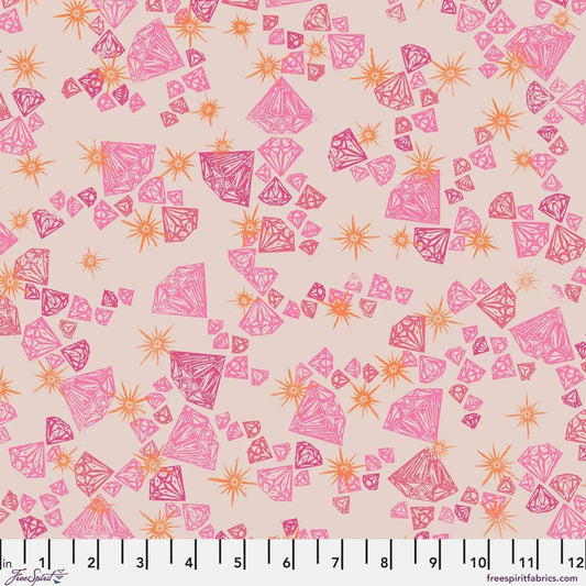 Pattern of pink and orange gemstones on a beige background with a ruler at the bottom for scale.