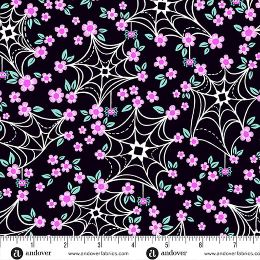 Pattern of cartoon-style spider webs and pink flowers on a black background with a ruler for scale