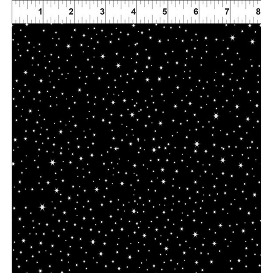 Black fabric with scattered white stars and a ruler at the top for scale.