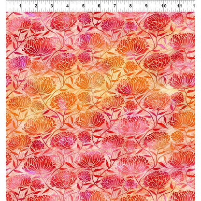 A floral fabric swatch with repeating stylized chrysanthemum flowers in pink, red, orange, and gold on a peach background, with a ruler at the top showing scale.