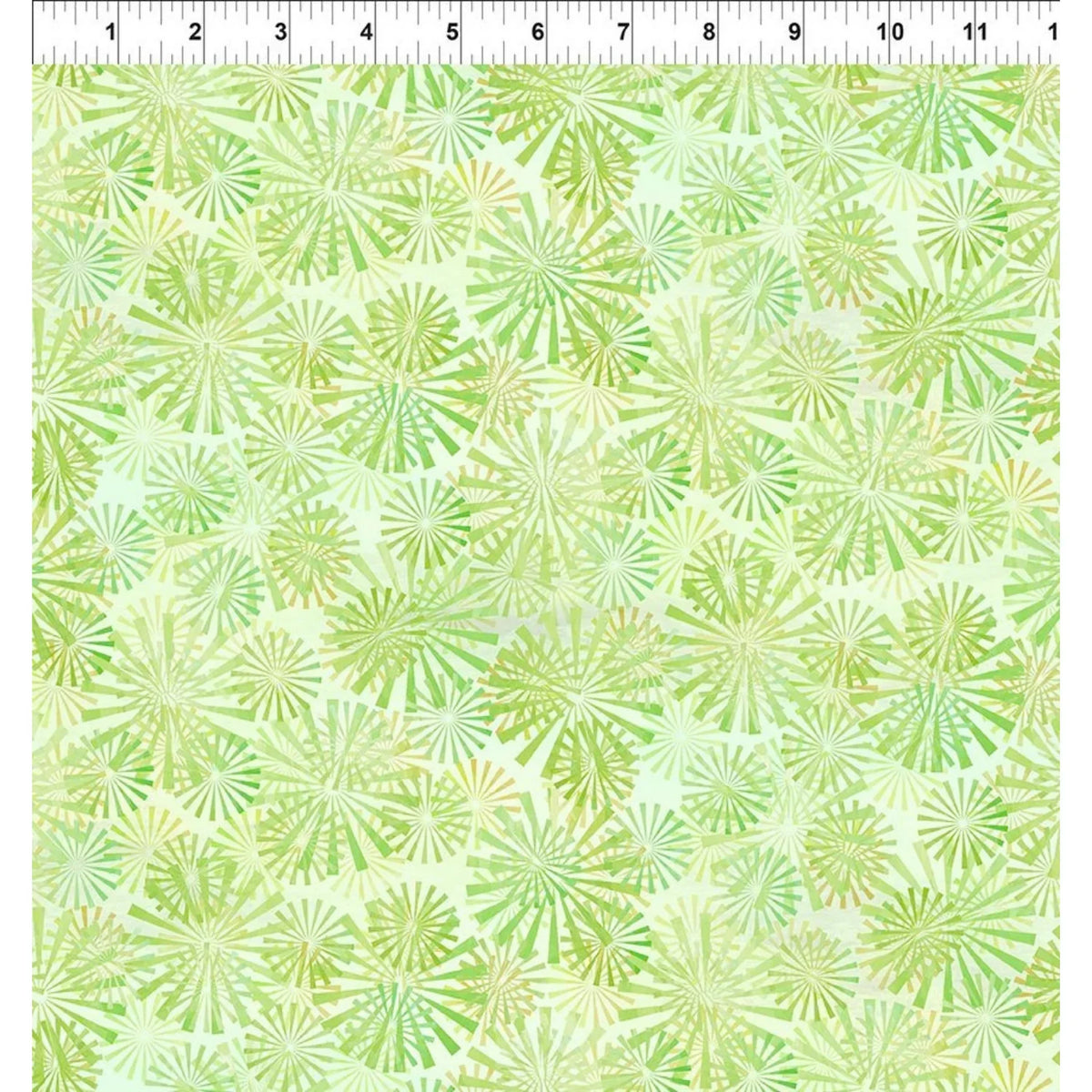 A fabric swatch with overlapping radial sunburst motifs in chartreuse and light-green on a spring green background. A ruler at the top edge indicates the scale of the print.