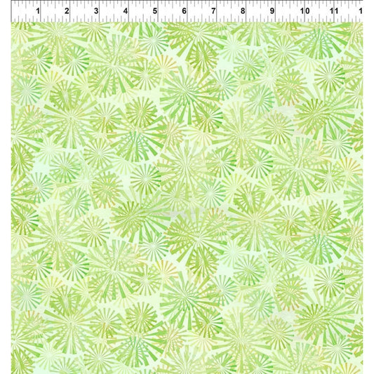 A fabric swatch with overlapping radial sunburst motifs in chartreuse and light-green on a spring green background. A ruler at the top edge indicates the scale of the print.