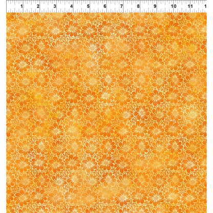 A fabric swatch featuring a repeating pattern of daisy-like flowers on a warm orange and yellow background, with a white ruler along the top edge for scale.