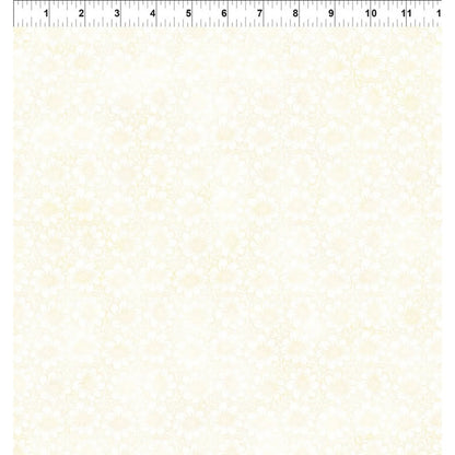 A fabric swatch with a delicate pale floral pattern on a warm off-white background, with a ruler along the top edge for scale.