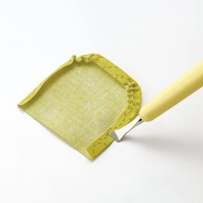 Yellow fabric applique piece with seams folded and creased by a Metal Hera tool