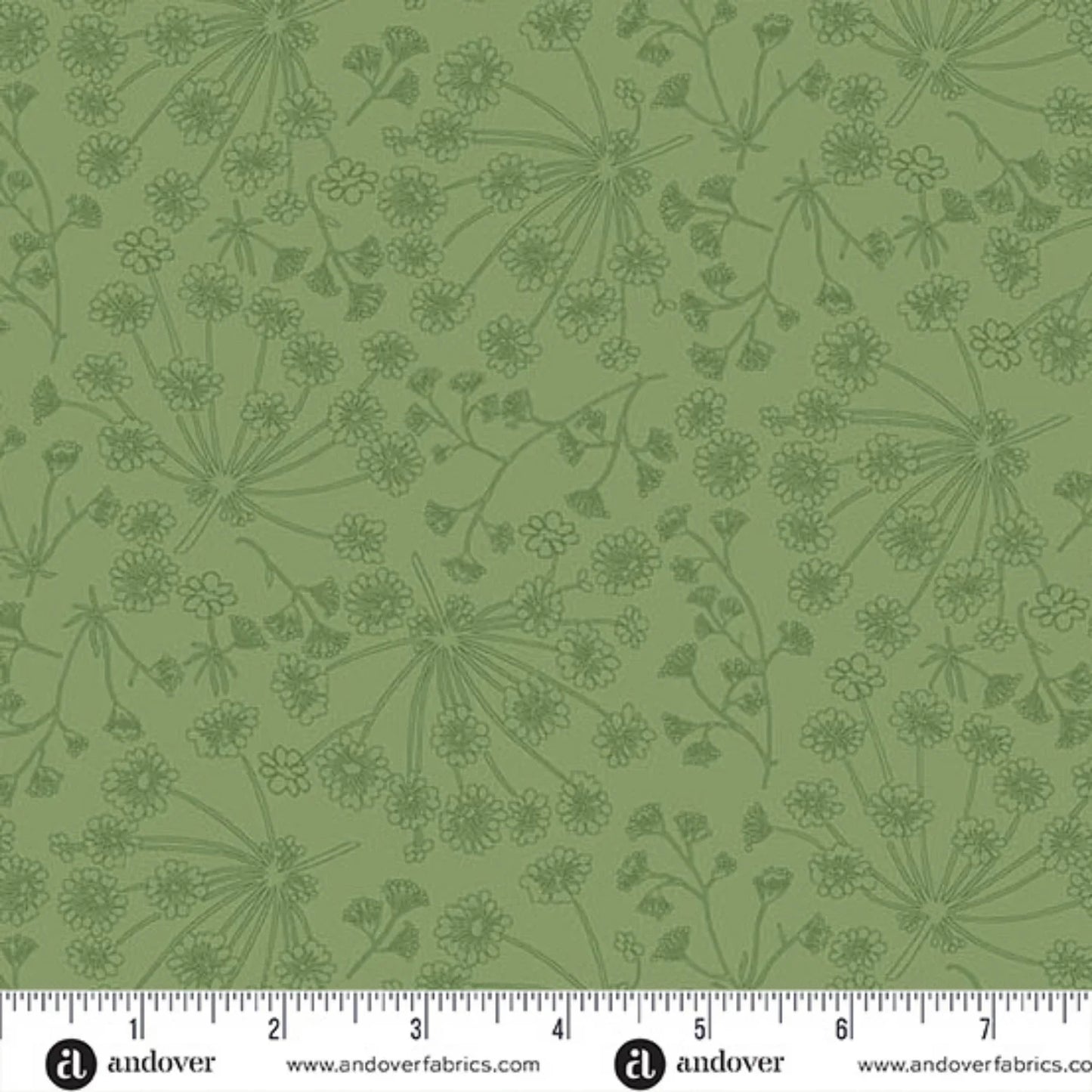 Green fabric with a repeating dark green botanical pattern of wildflowers and stems, shown with a white ruler along the bottom edge for scale.