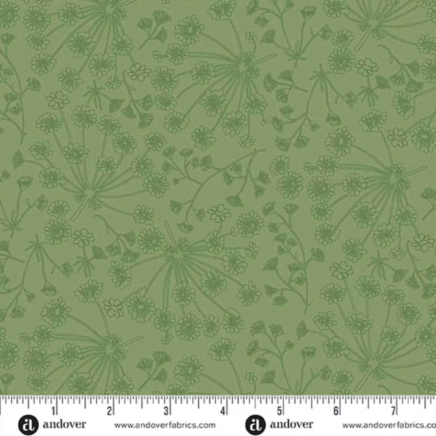 Green fabric with a repeating dark green botanical pattern of wildflowers and stems, shown with a white ruler along the bottom edge for scale.