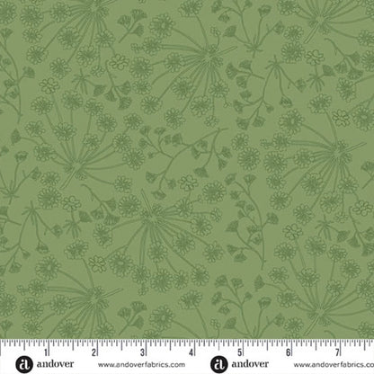 Green fabric with a repeating dark green botanical pattern of wildflowers and stems, shown with a white ruler along the bottom edge for scale.