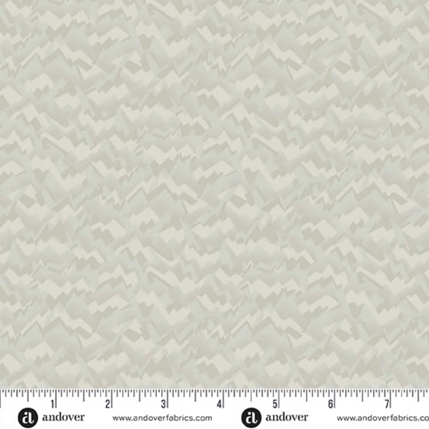 A fabric swatch featuring an abstract, fragmented, and jagged texture in layered shades of soft birch grey, smoky taupe, and warm cream. Ruler at the bottom for scale.
