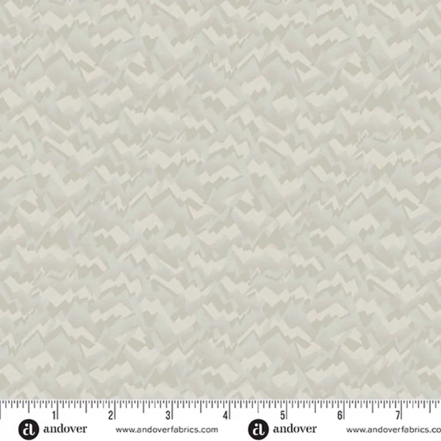 A fabric swatch featuring an abstract, fragmented, and jagged texture in layered shades of soft birch grey, smoky taupe, and warm cream. Ruler at the bottom for scale.