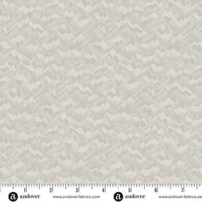 A fabric swatch featuring an abstract, fragmented, and jagged texture in layered shades of soft birch grey, smoky taupe, and warm cream. Ruler at the bottom for scale.