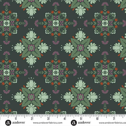 A repeating fabric pattern featuring a bold, symmetrical folk-art medallion design with intricate floral and leaf motifs in soft sage, purple, red, and cream on a deep forest-green background. Ruler at the bottom for scale.