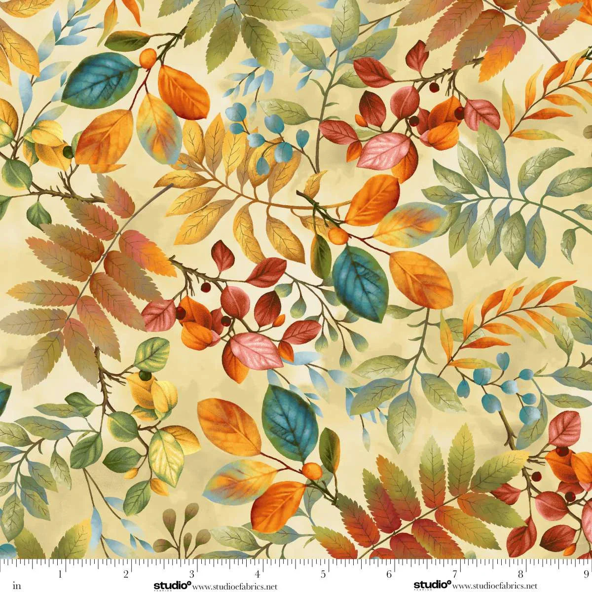 Fabric with a colorful autumn leaf pattern on a beige background with a ruler at the bottom for scale.