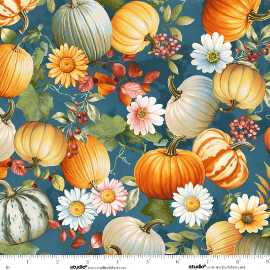 Pattern of pumpkins, flowers, and leaves on a blue background. Ruler at the bottom for scale.
