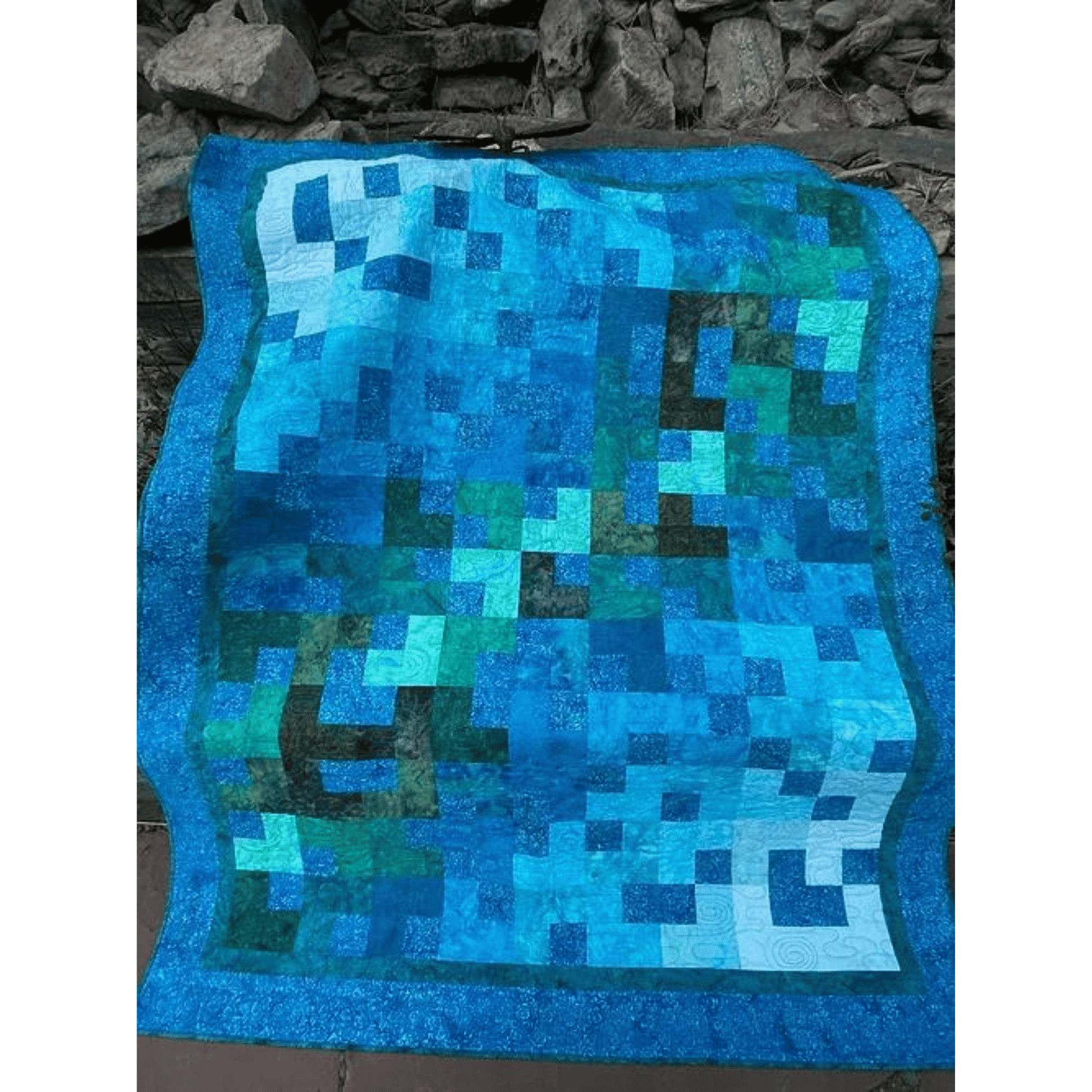 This Ambling Quilt sample features simple patchwork squares and rectangles in a colorful blue, teal, and green gradient.