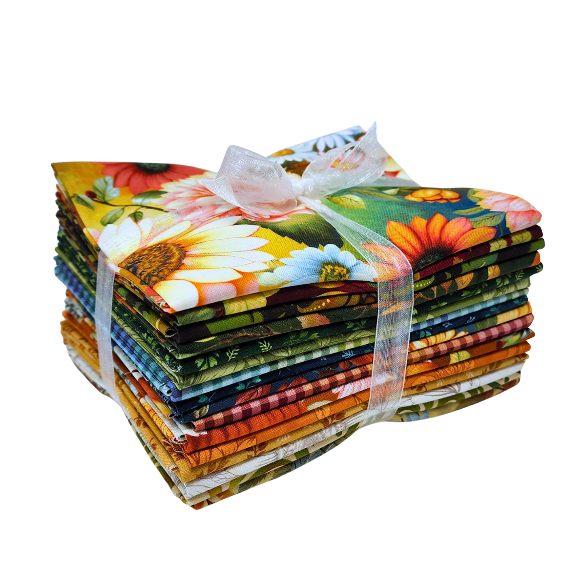 A stack of colorful fabric bundles tied together with a sheer white ribbon, featuring a vibrant floral and botanical print with sunflowers, daisies, and green leaves.