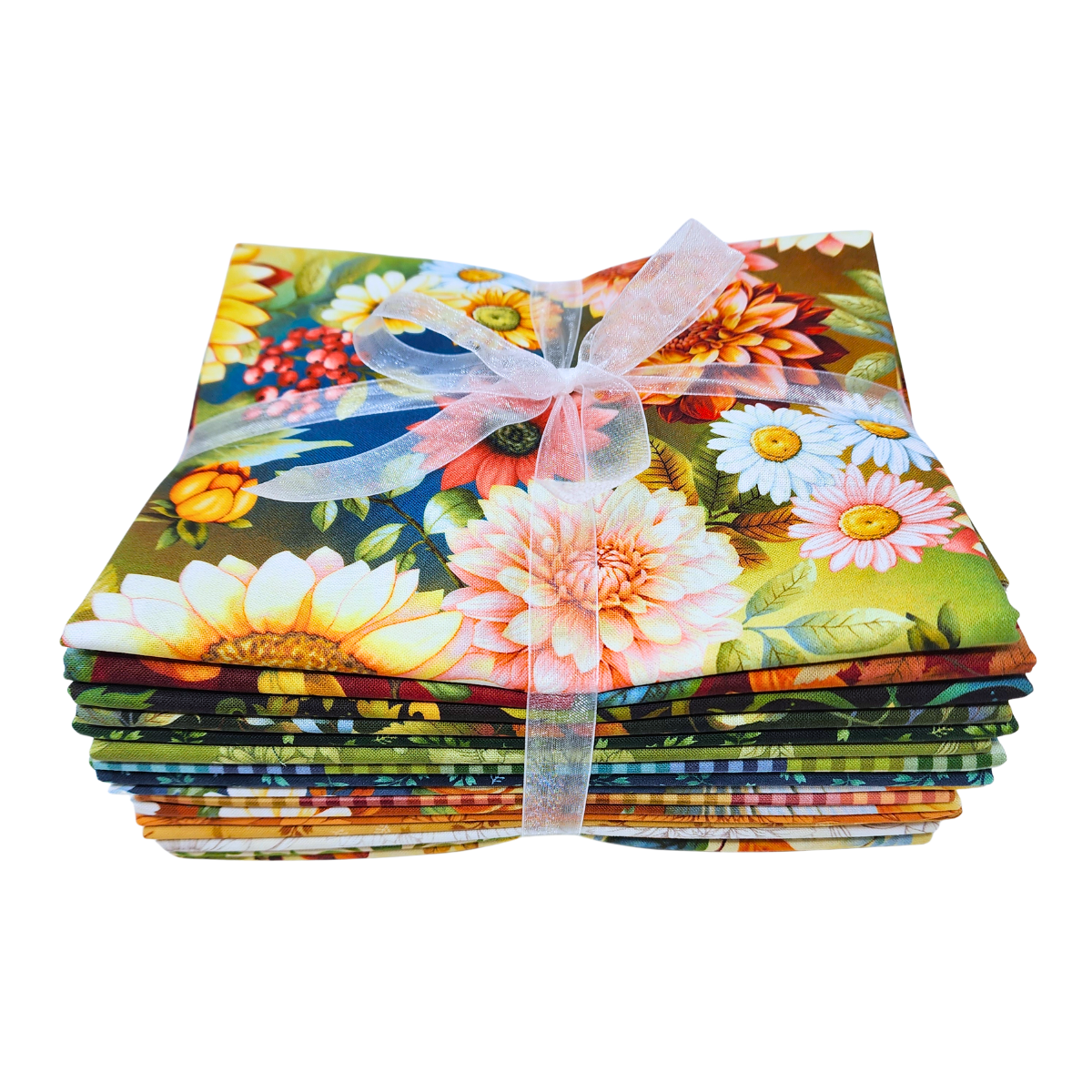 A stack of colorful fabric bundles tied together with a sheer white ribbon, featuring a vibrant floral and botanical print with sunflowers, daisies, and green leaves.