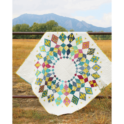 The Cadence Court Quilt made with red, blue, and navy wedges accented with gold against a white background.