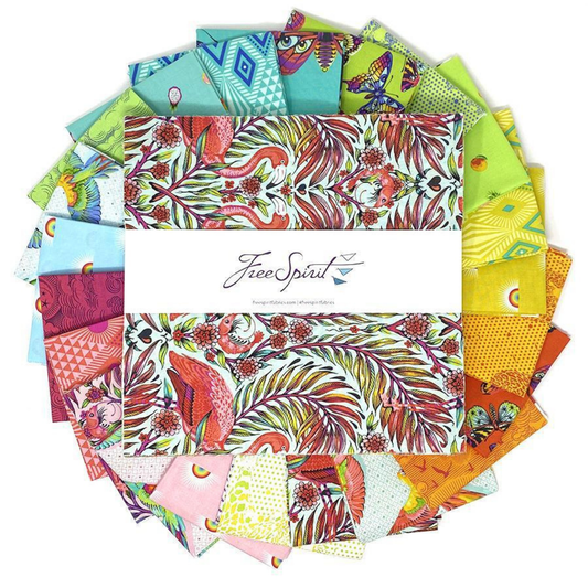 Collection of colorful fabric squares arranged in a circle with a layer cake in the center
