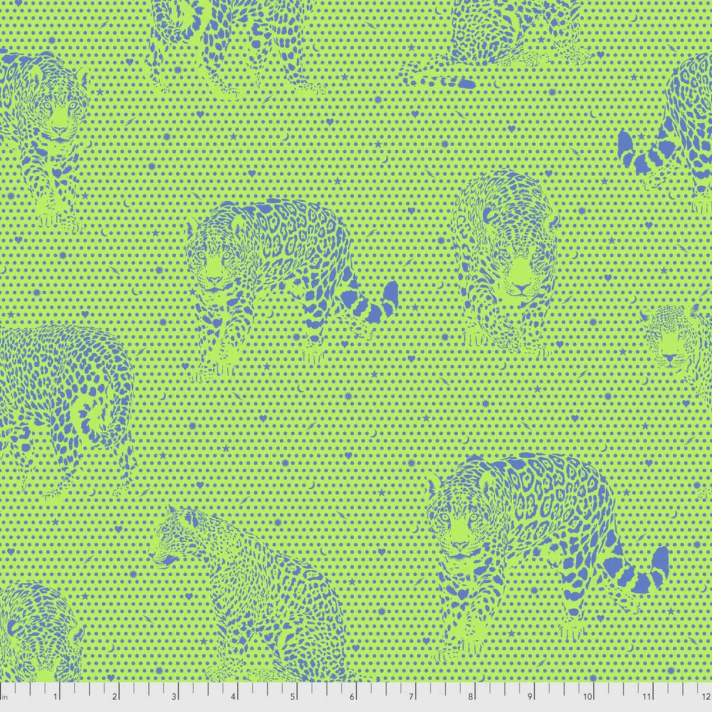 Pattern of teal jaquars on a green background with a ruler for scale