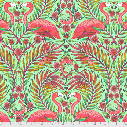 Colorful pattern of pink flamingos and green foliage on a green background with a ruler for scale